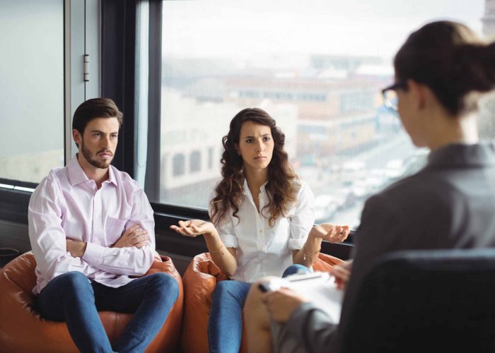 Annoyed couple talking to a marriage counselor during therapy
